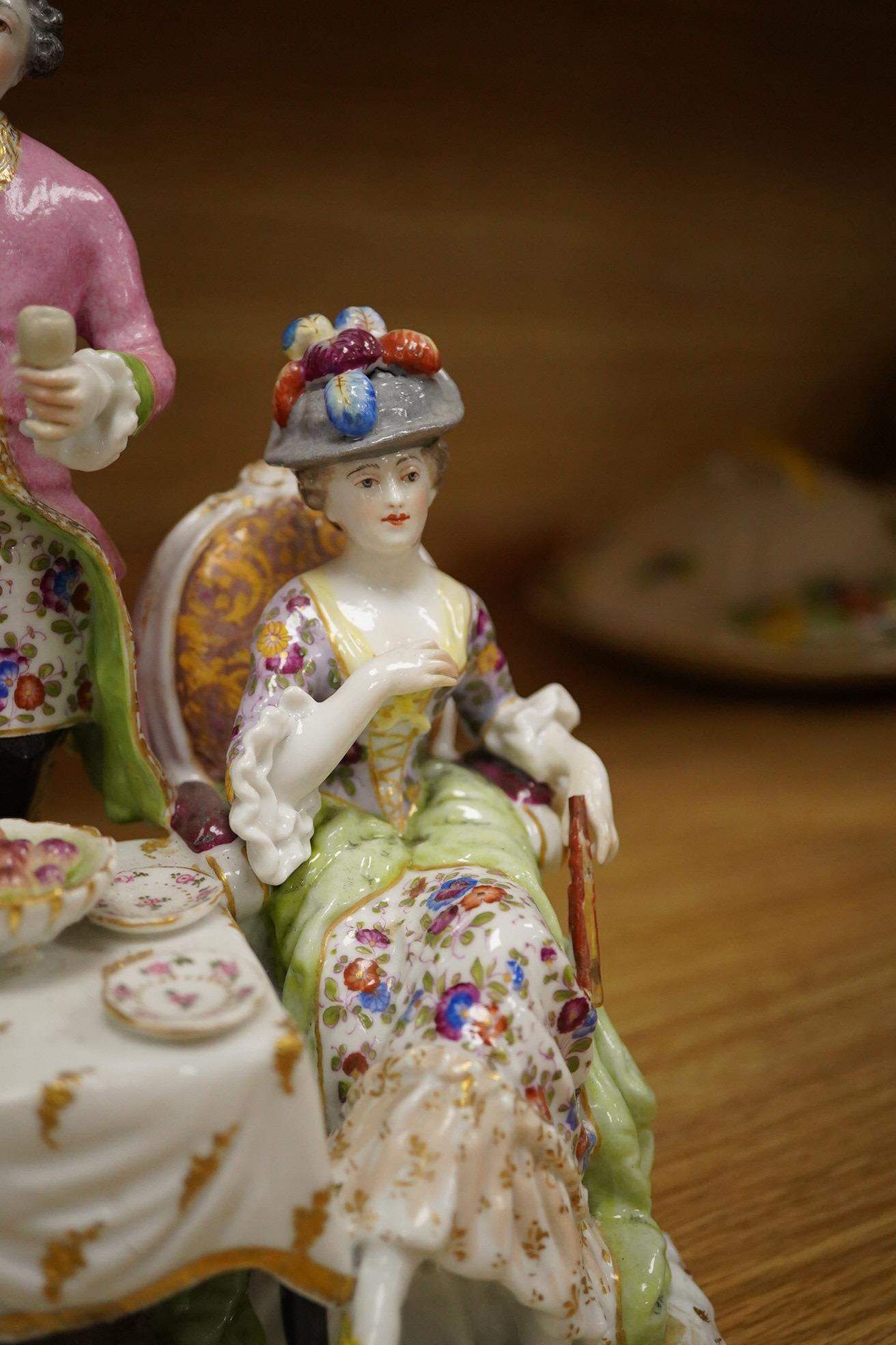 A 19th century Dresden porcelain group of three figures at a table, 24cm high